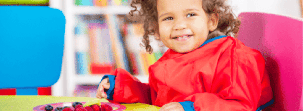 Girl enjoying snack time in her nursery school