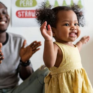 Child dancing with their parent watching