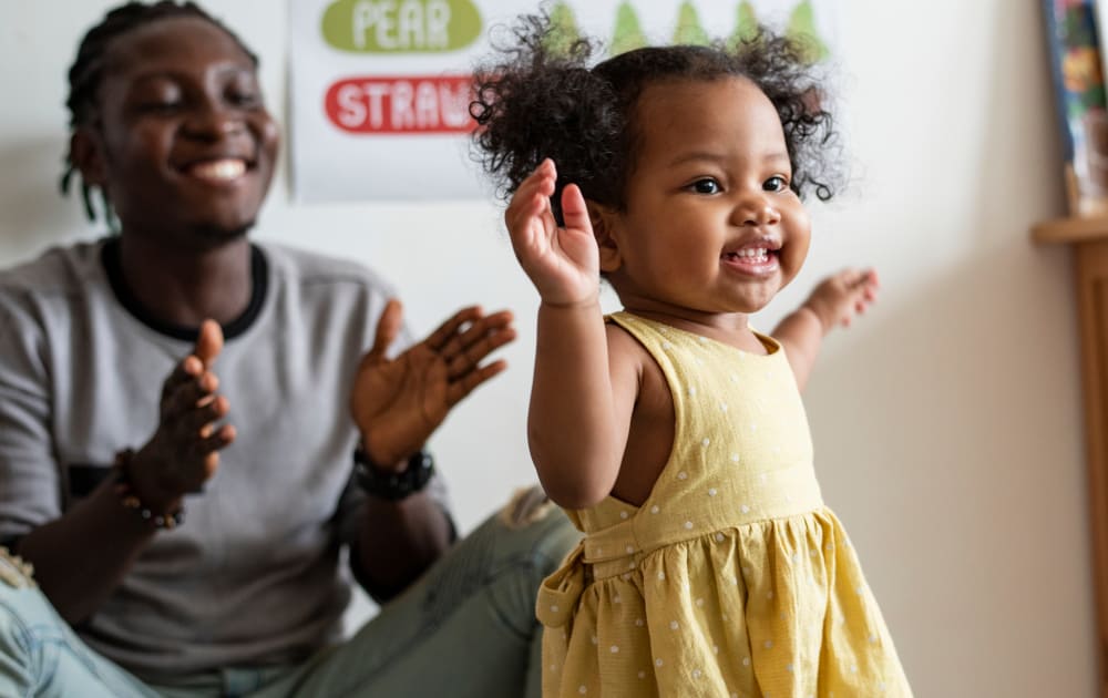 Child dancing with their parent watching
