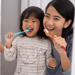 Child brushing her teeth with a nursery practitioner