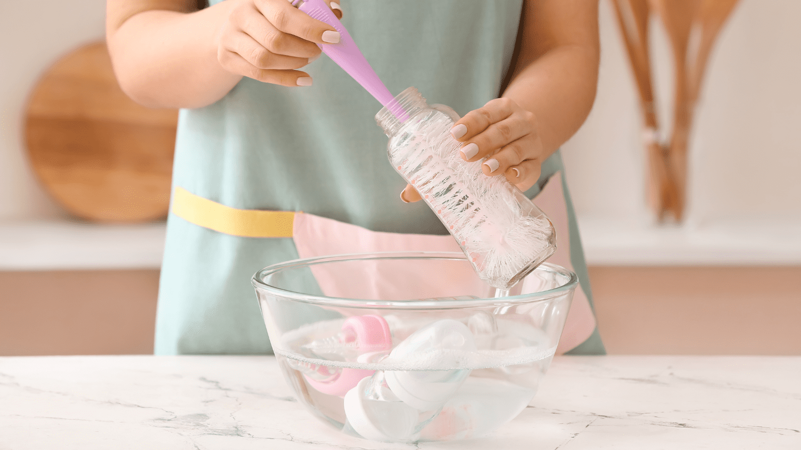 Mother cleaning baby bottle before sterilising it
