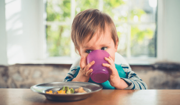 Toddler using an open top cup