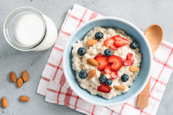 Porridge with berries and nuts along side a glass of milk