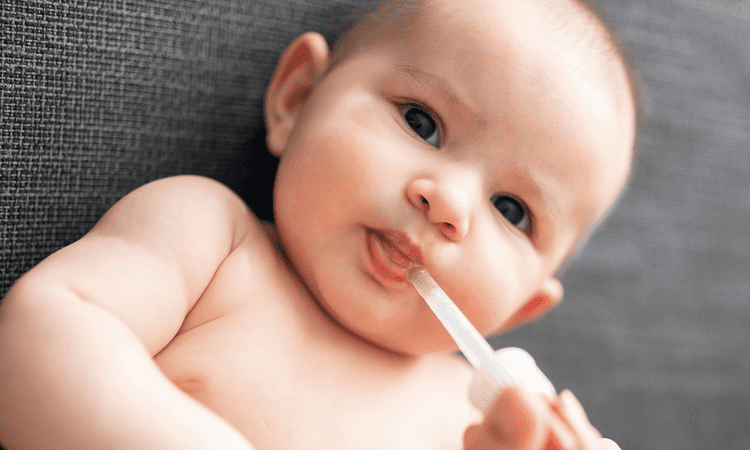 Baby having vitamin drops
