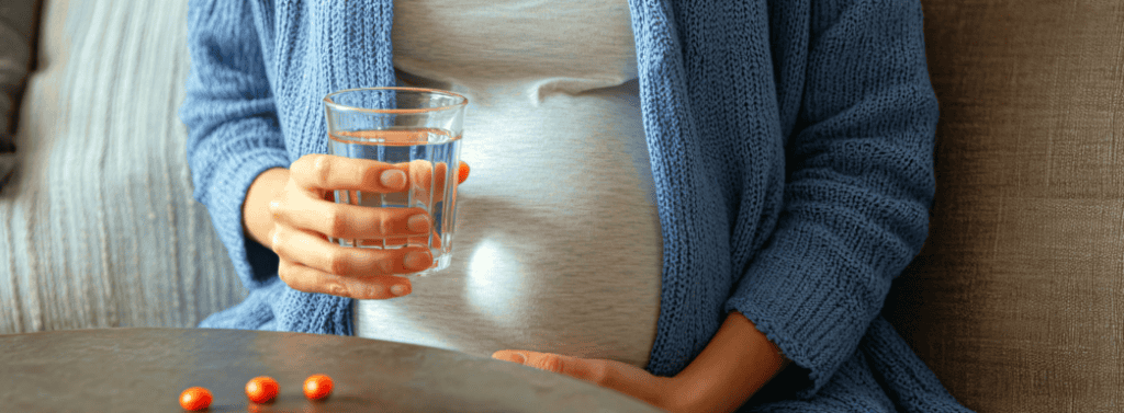 Pregnant woman taking vitamin supplement
