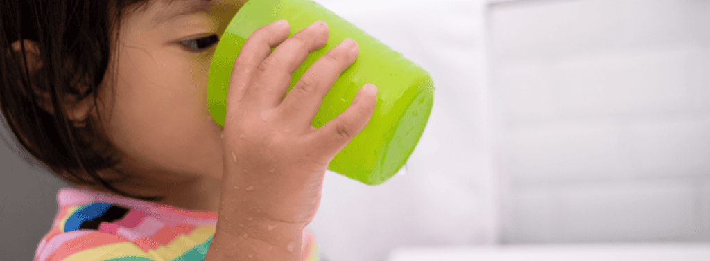 Gril drinking froom a green cup
