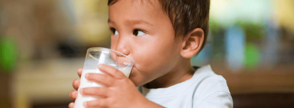 Toddler drinking a glass of milk