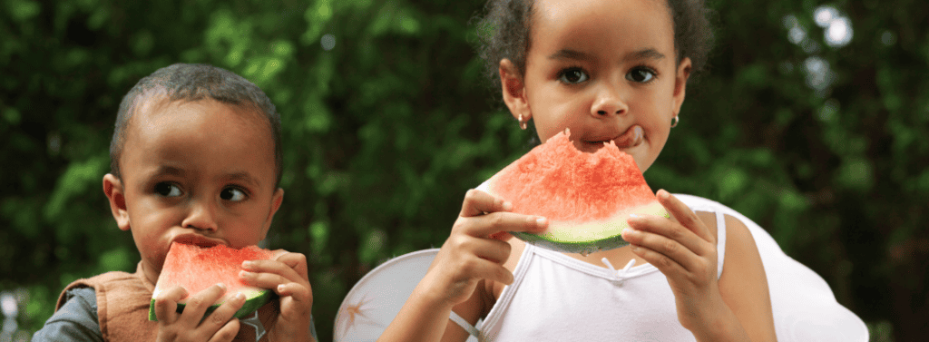 Brother and sister enjoying a watermelon slice