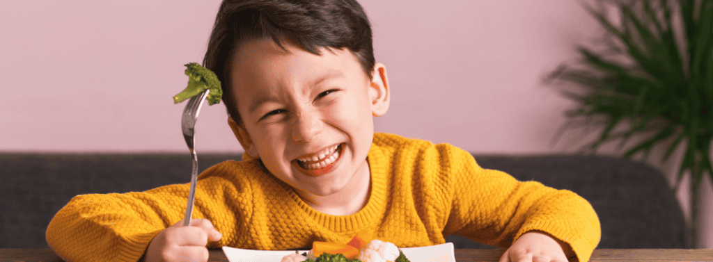 Children enjoying eating broccoli
