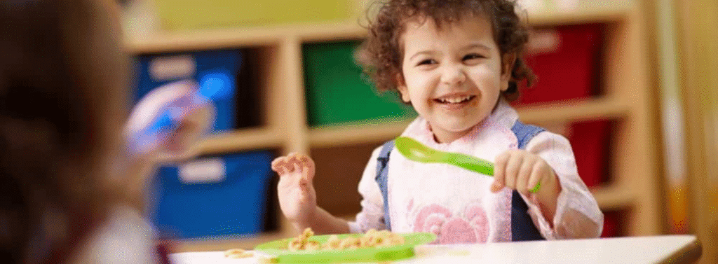 Happy child eating at nursery