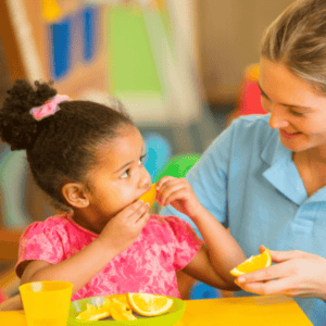 Nursery practitioner with child at meal time